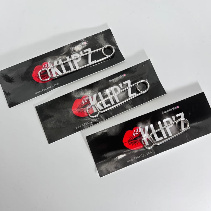 Three Klip’zo branded stainless steel roach clips with red lip labels